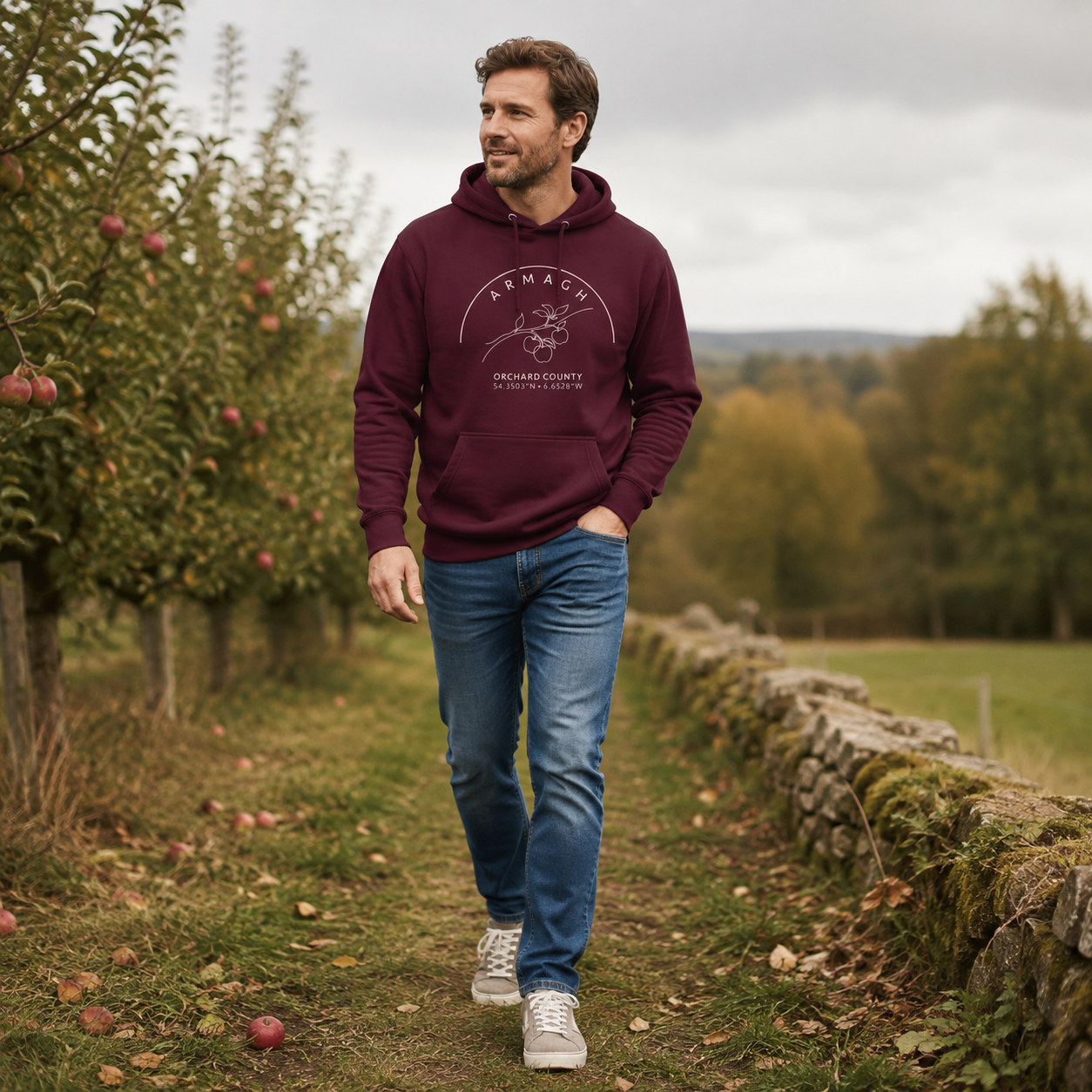Man wearing the Armagh Blossom maroon hoodie in an Armagh orchard
