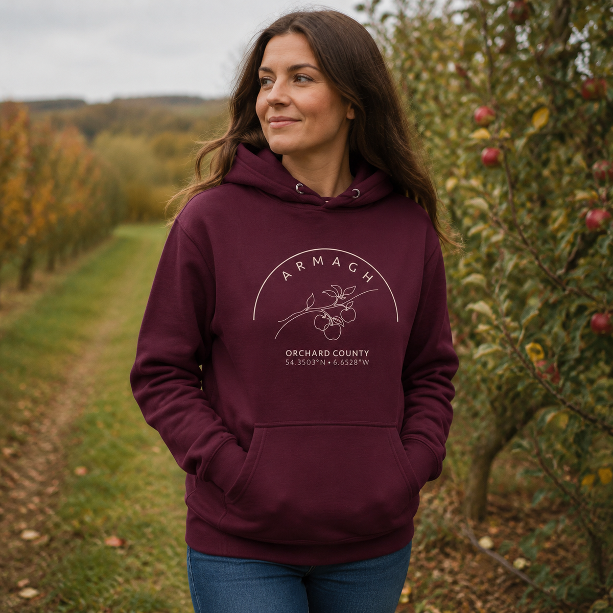 Woman wearing the Armagh Blossom maroon hoodie in an Armagh orchard