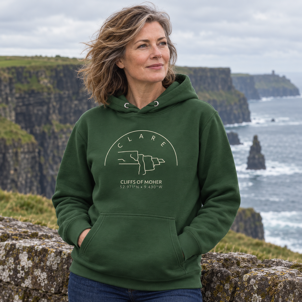 Woman wearing the Clare Cliffs of Moher forest green hoodie at the Cliffs of Moher