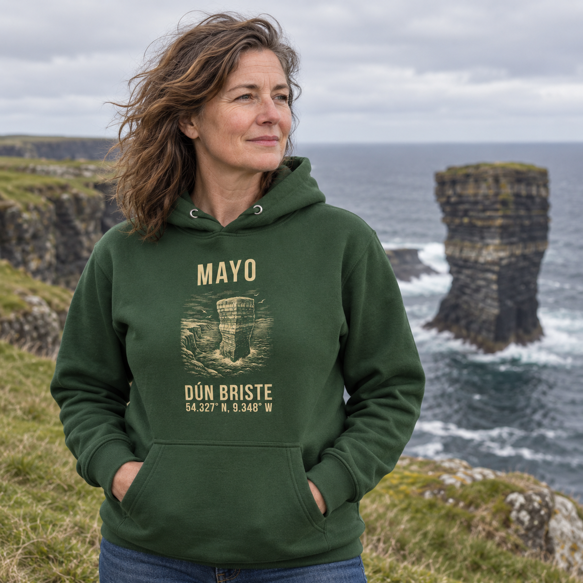 Woman wearing the Mayo Dún Briste forest green hoodie at Downpatrick Head
