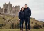 Two people wearing matching navy blue hoodies with a castle in the background