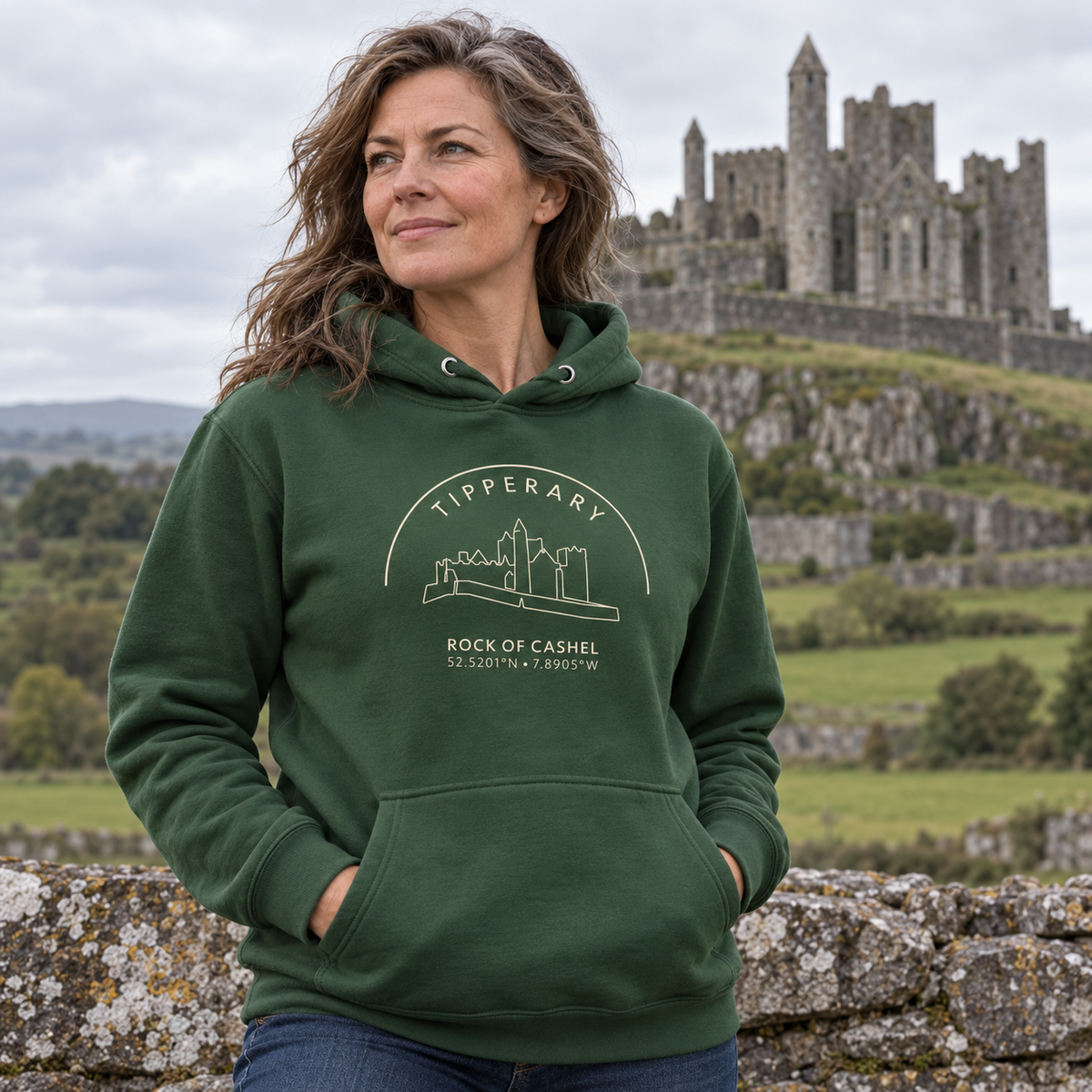 Woman wearing the Tipperary Rock of Cashel forest green hoodie at the Rock of Cashel